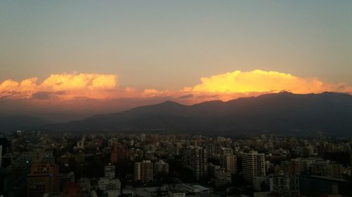 High angle view of illuminated cityscape against sky at sunset