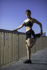 Side view of woman exercising by railing