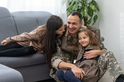 Portrait of happy family sitting on sofa at home