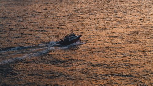 High angle view of boat sailing on sea during sunset