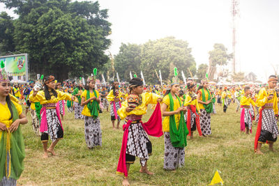 Group of people on field against trees