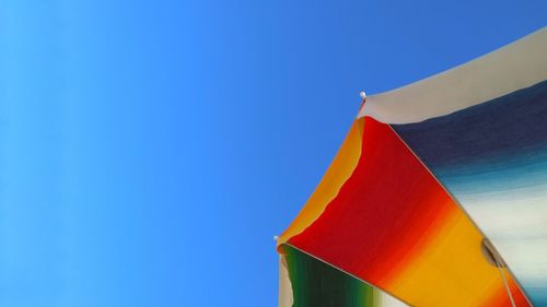 Low angle view of flag against clear blue sky