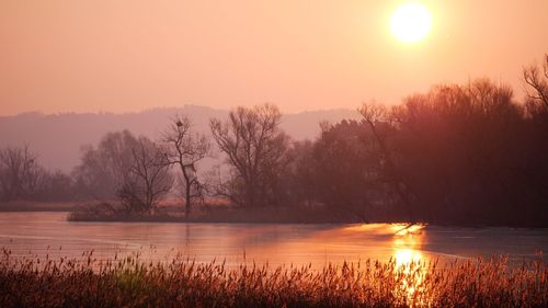 Scenic view of lake against sky during sunset