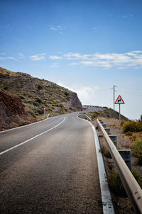 Road leading towards mountain against sky