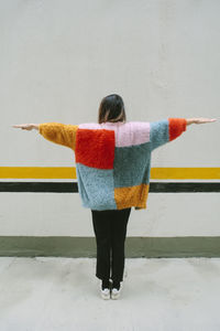 Rear view of woman standing against wall