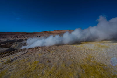 View of volcanic landscape against blue sky