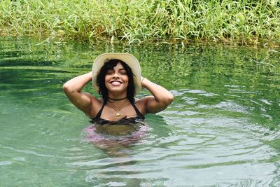 Portrait of smiling young woman swimming in lake