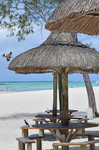 Gazebo on beach by sea against sky
