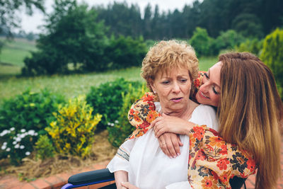 Cheerful daughter visiting ill mother in nursing home at park