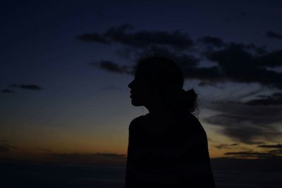 Silhouette man standing by sea against sky during sunset