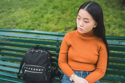 Thoughtful young woman sitting on bench