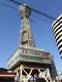 Low angle view of communications tower against blue sky