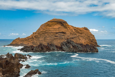 Scenic view of rock formation in sea against sky