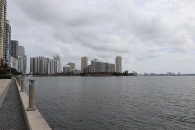 City by river against sky