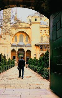 Rear view of man walking on walkway