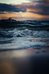 Surface level of sea against sky during sunset