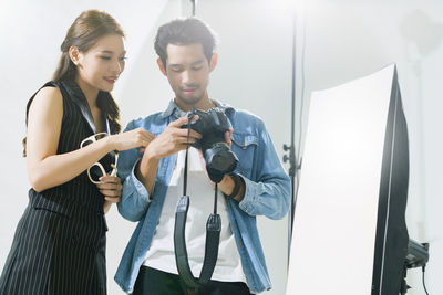 Young couple holding camera