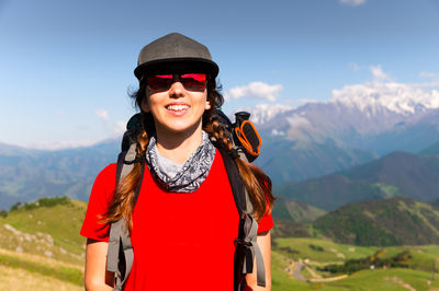 Portrait of young woman standing against mountain