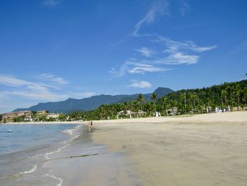 Scenic view of beach against blue sky