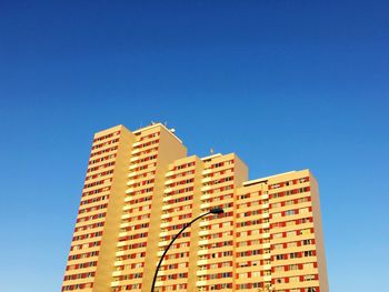 Low angle view of apartment building against blue sky
