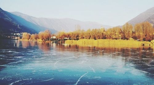 Scenic view of lake by mountain against sky