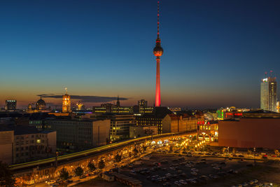 Illuminated city against clear sky