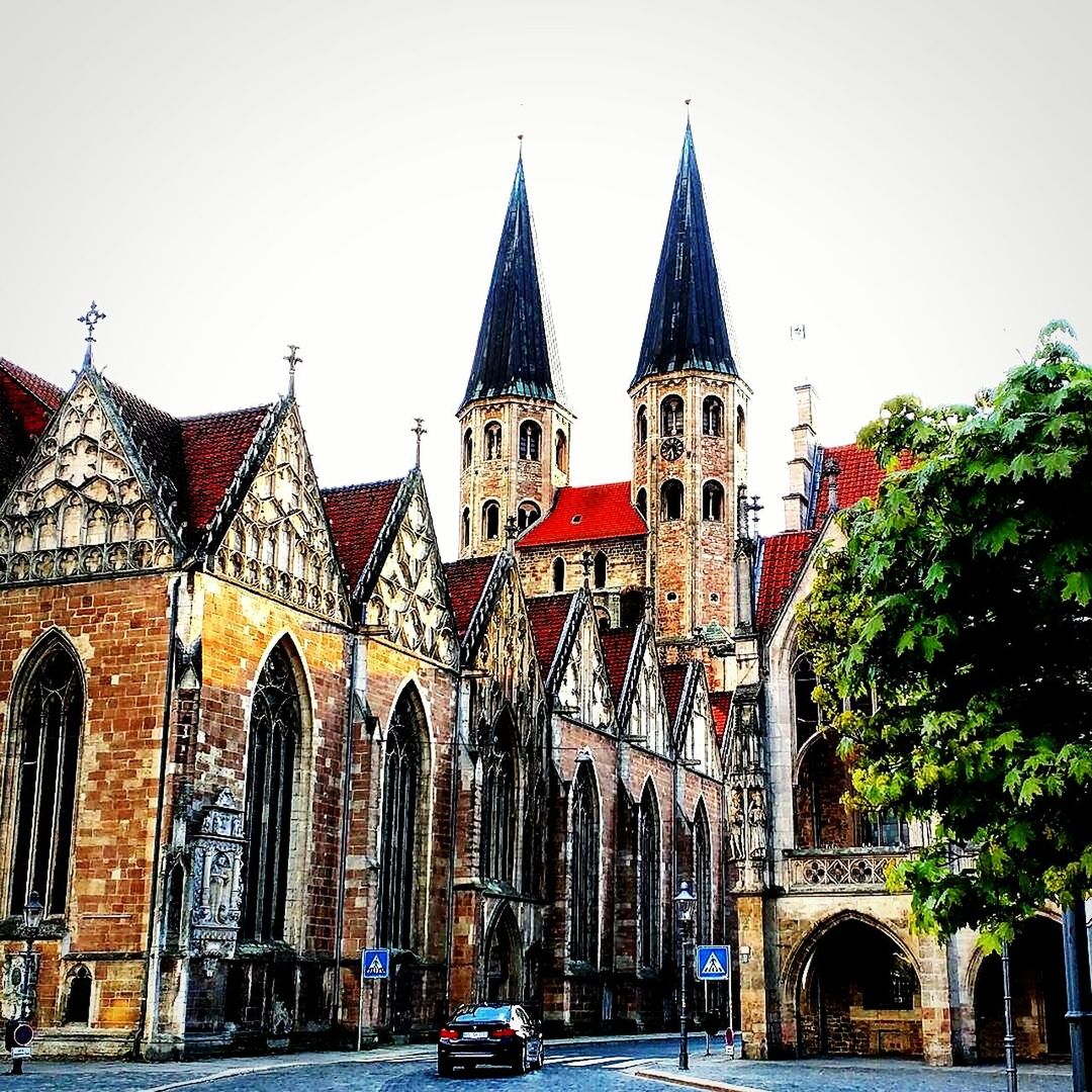 architecture, building exterior, built structure, place of worship, religion, church, spirituality, clear sky, facade, low angle view, cathedral, arch, car, street, history, tree, incidental people, outdoors