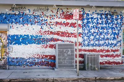 Stack of multi colored flags on wall