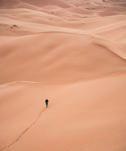 Lonely man walking throgh the desert from above