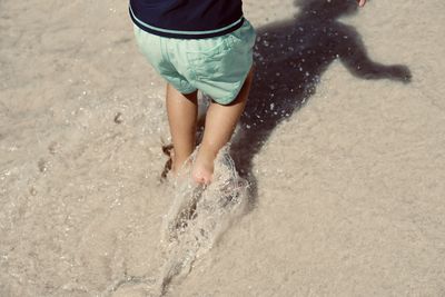 Low section of woman standing at beach