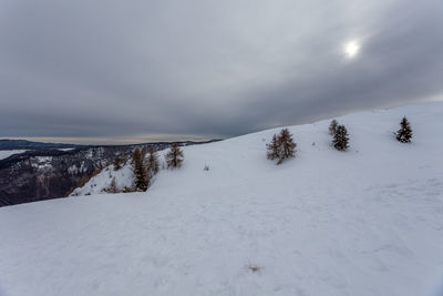 Snow covered land and mountains against sky