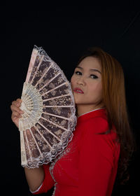 Portrait of woman wearing hat against black background