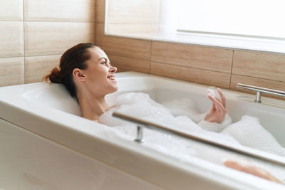 Smiling woman in bathtub