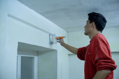 A young man painted white his new house, on stairs