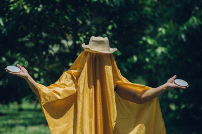 Man covering body with yellow fabric