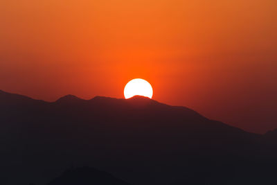 Scenic view of silhouette mountains against romantic sky at sunset