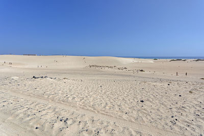 Scenic view of desert against clear blue sky