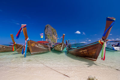 Boats moored on beach against sky