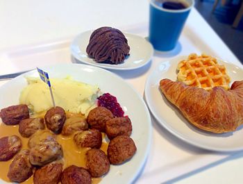 High angle view of meatballs and croissant served in plates