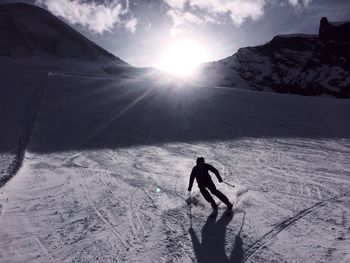 High angle view of man skiing on snowy field during sunny day