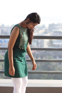 Full length of woman standing against railing