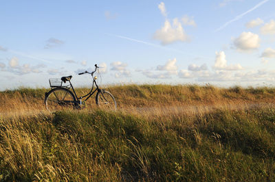 Bicycle on field against sky