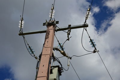 Low angle view of electricity pylon against sky