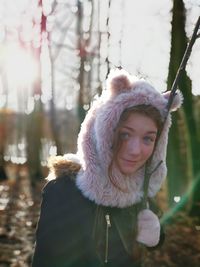 Portrait of cute girl standing against bare trees during winter