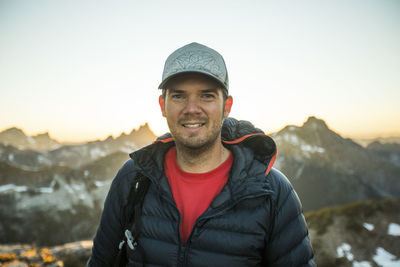 Portrait of back lit man standing at sunset in mountains.