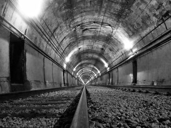 Railroad tracks in illuminated tunnel