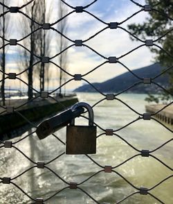 Close-up of padlocks on chainlink fence