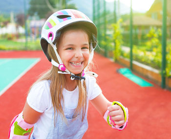Portrait of a smiling girl wearing helmet in park