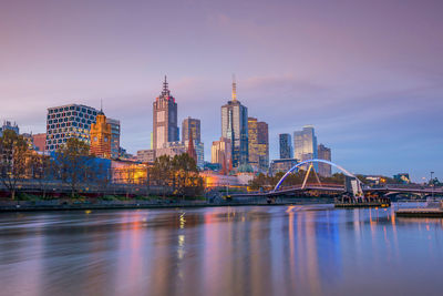 Illuminated buildings in city at waterfront