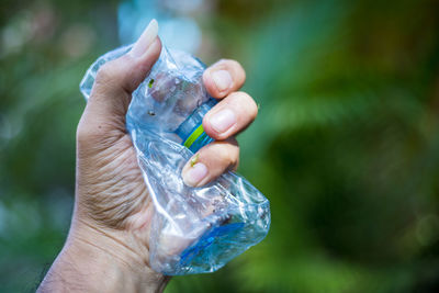 Close-up of hand holding glass of water